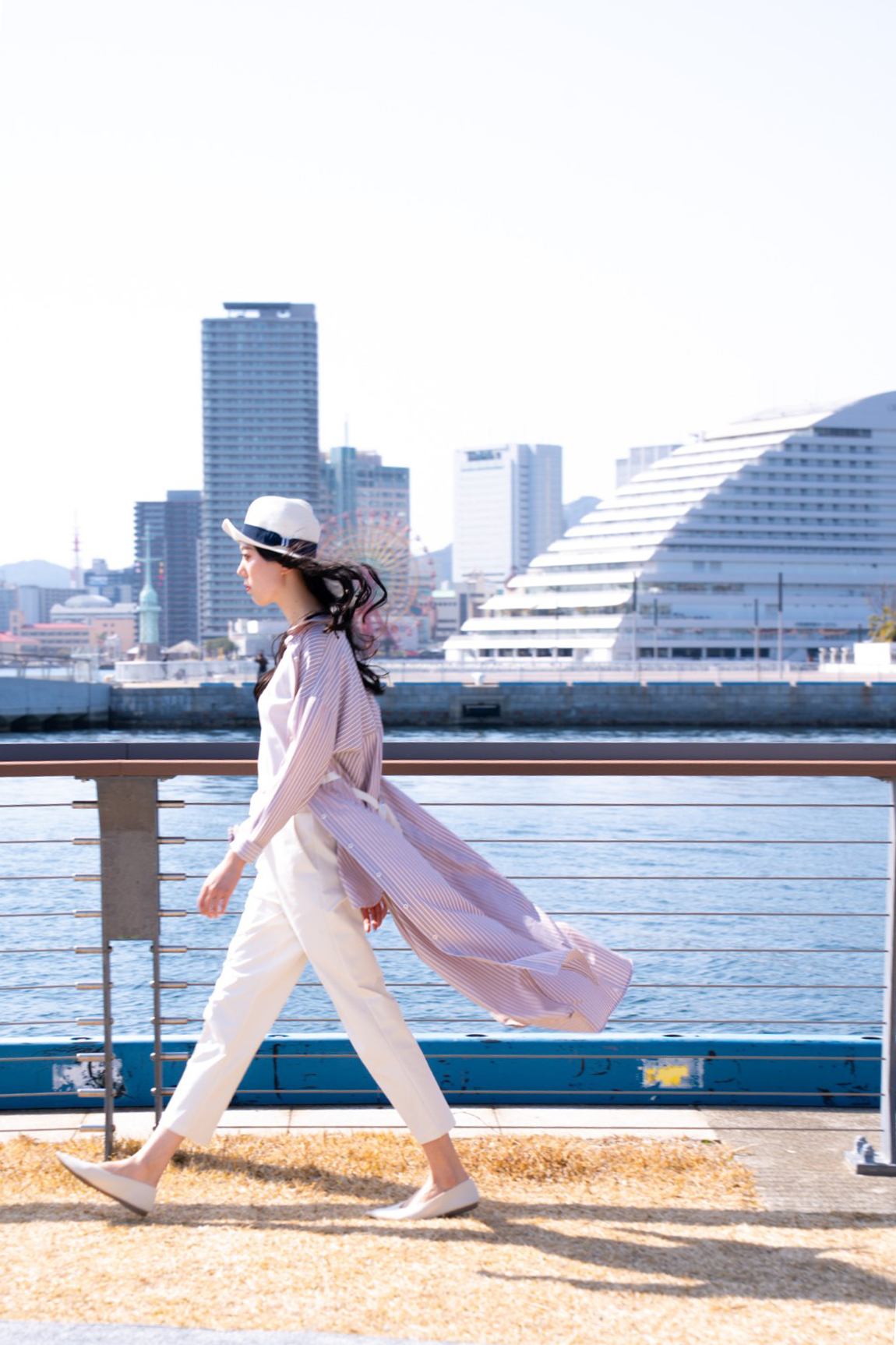 神戸の景色を背景に歩くモデル